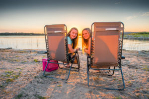 Two girls enjoying the beach at Lake Travis during sunset.