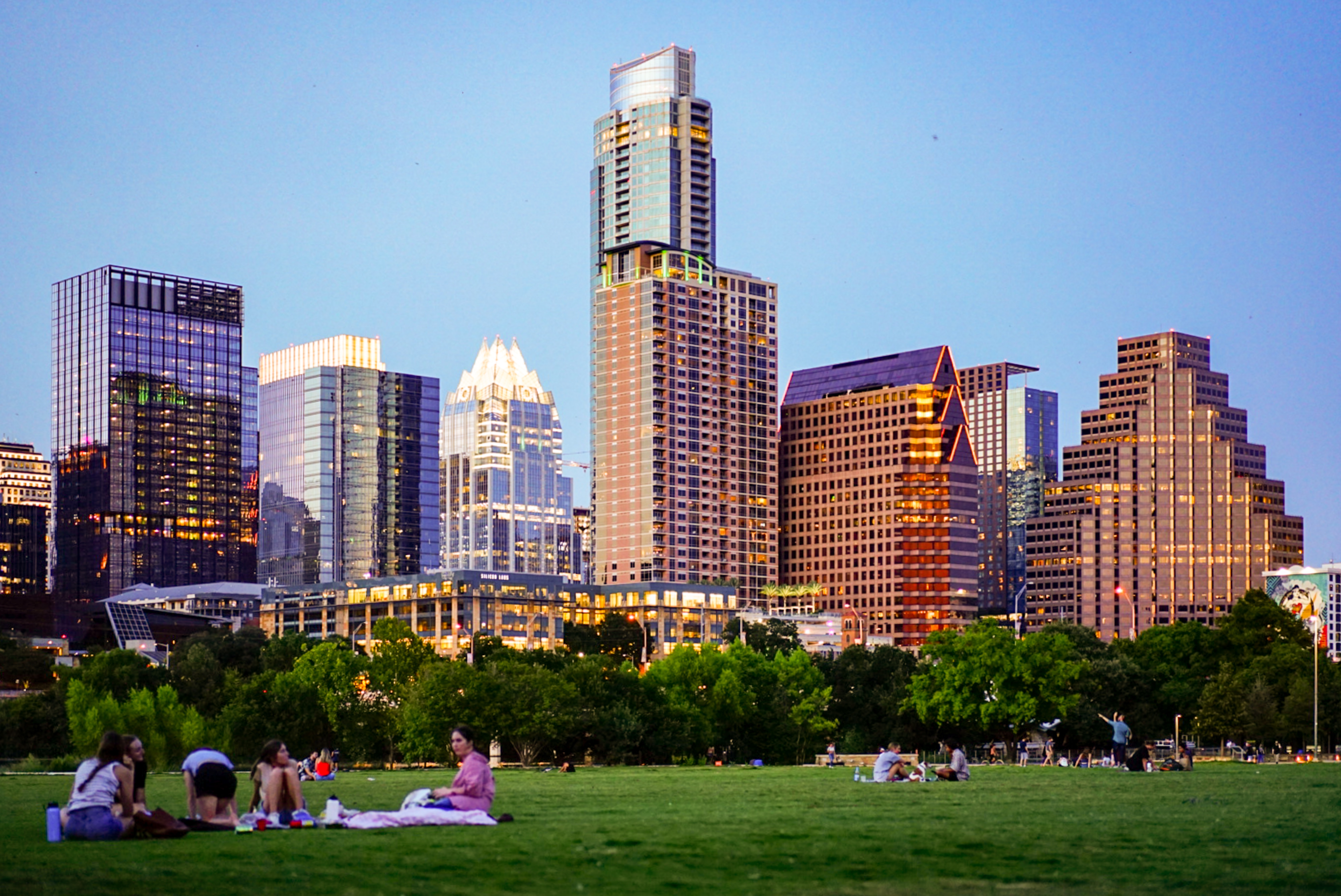 People having picnics in a green park next to downtown Austin, Texas