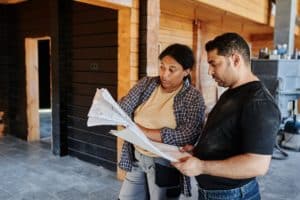 woman construction worker showing home blueprints